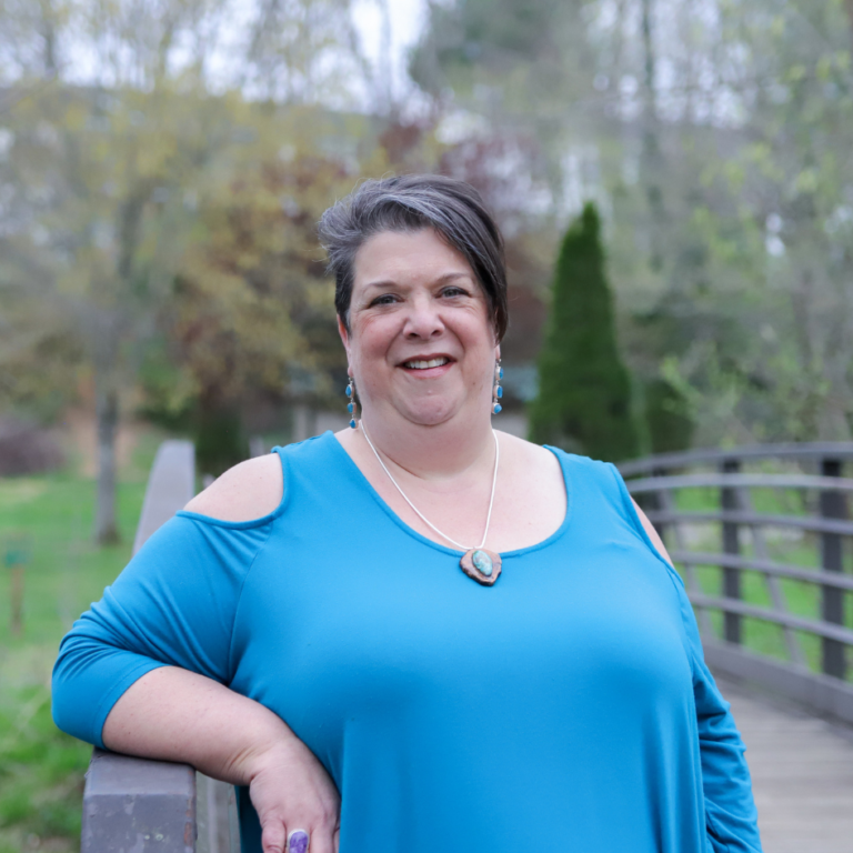 An Image of Yvette LeFlore from Healing with Yvette with a blue top and nature in the background.